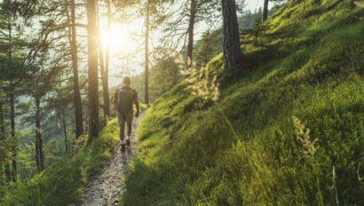 senior-man-trail-hiking-in-the-forest-at-sunset