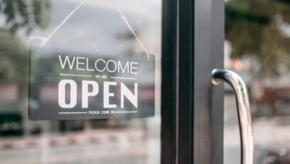 closeup-of-open-and-welcome-to-store-sign-board-at-the-door