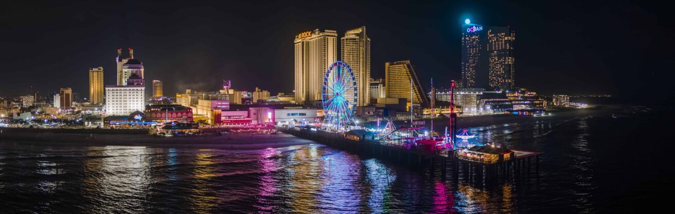 panoramic-aerial-view-of-the-broadwalk-on-the-waterfront-in-atlantic-city-downtown-the-famous-gambling-center-of-the-east-coast-usa-with-multiple-casinos-and-amusing-park-with-a-ferris-wheel-on-a-pi