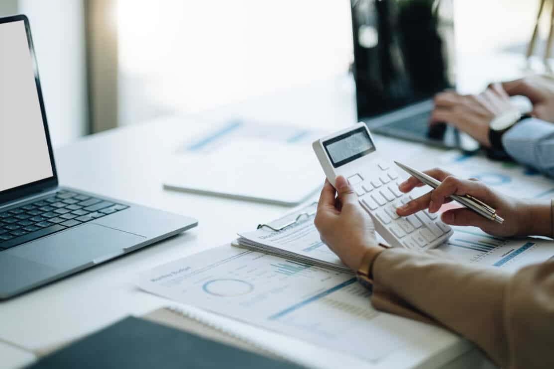 businesswoman-accountant-hand-working-on-calculator-to-calculate-financial-data-report-accountancy-document-and-laptop-computer-at-office-business-concept