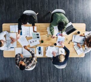 An aerial view of a group of people working together at a table.