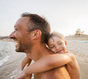 A smiling boy hugging his father.