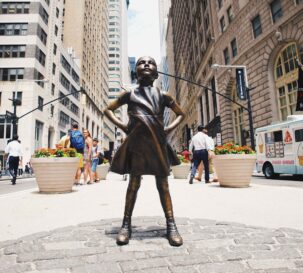 A sculpture of a girl wearing a dress.