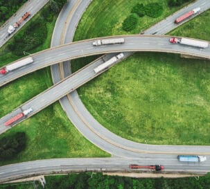 Aerial view of semi trucks on a highway interchange.