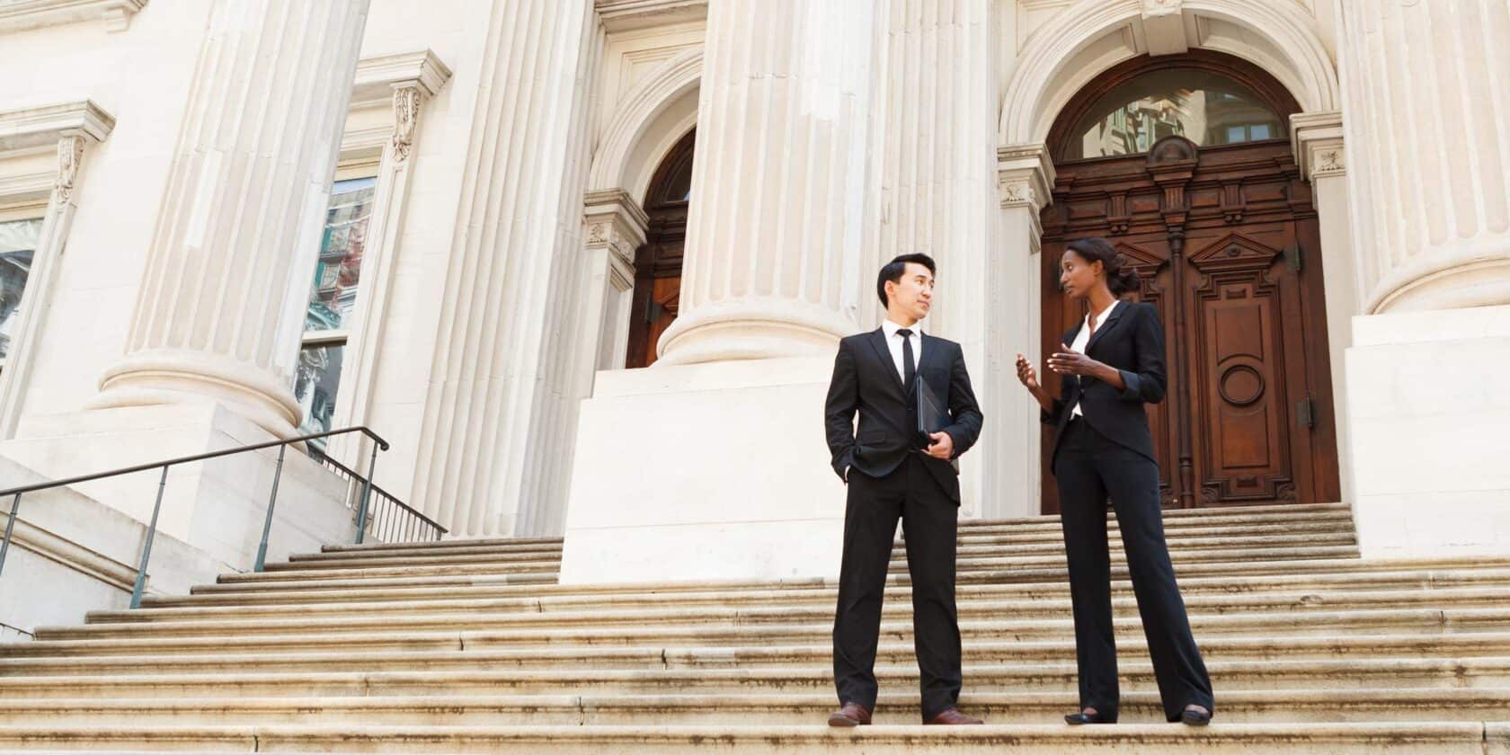 Two professionals standing outside of a building.