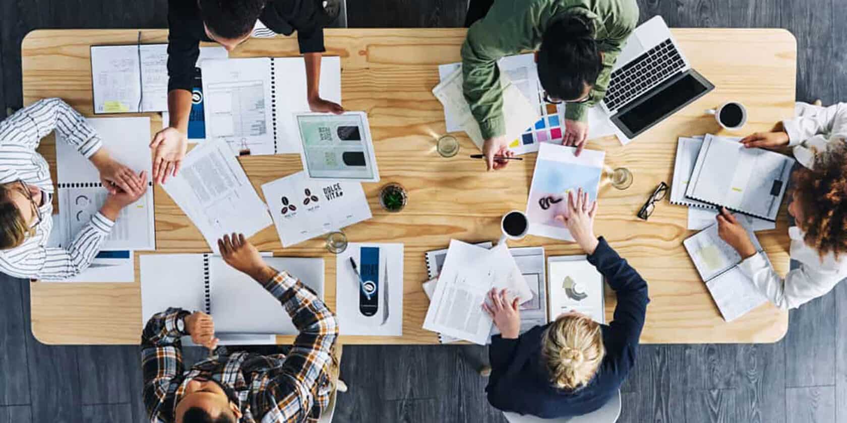 An aerial view of a group of people working together at a table.